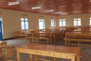 Ein neuer Klassenraum mit vielen Holzbänken und Tischen. 